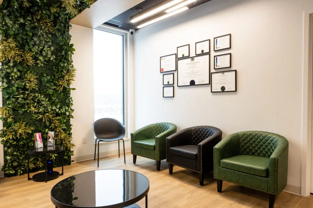 La salle d'attente de la Clinique médico-esthétique et dermatologique Derma M à Trois-Rivières. On y voit une belle salle lumineuse avec de la verdure et des fauteuils confortables.